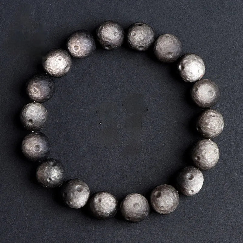 Natural obsidian crater ball bracelet with polished beads in silver or golden meteorite colours