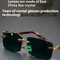 Dark green frameless sunglasses with a protective case and cleaning cloth.