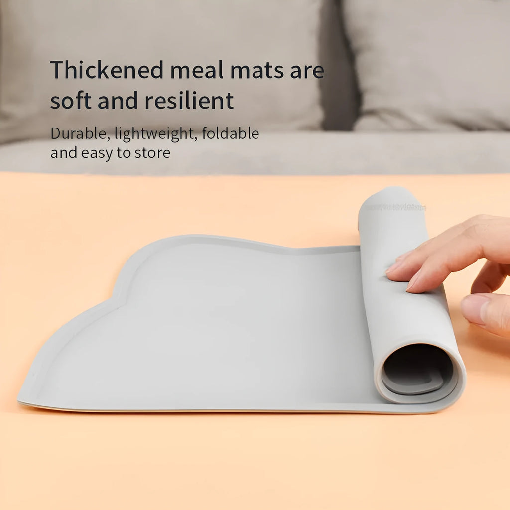 Blue silicone cat head-shaped pet feeding mat on a wooden floor.