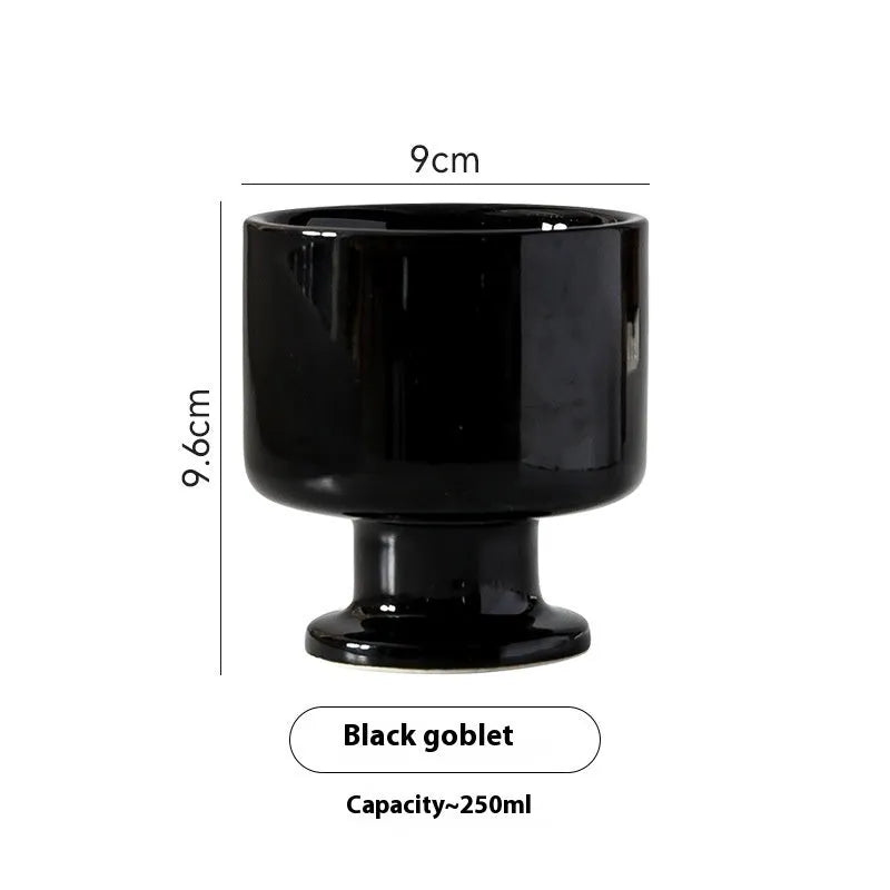 Hand-pinched irregularly shaped ceramic mug in a solid colour, shown on a table.