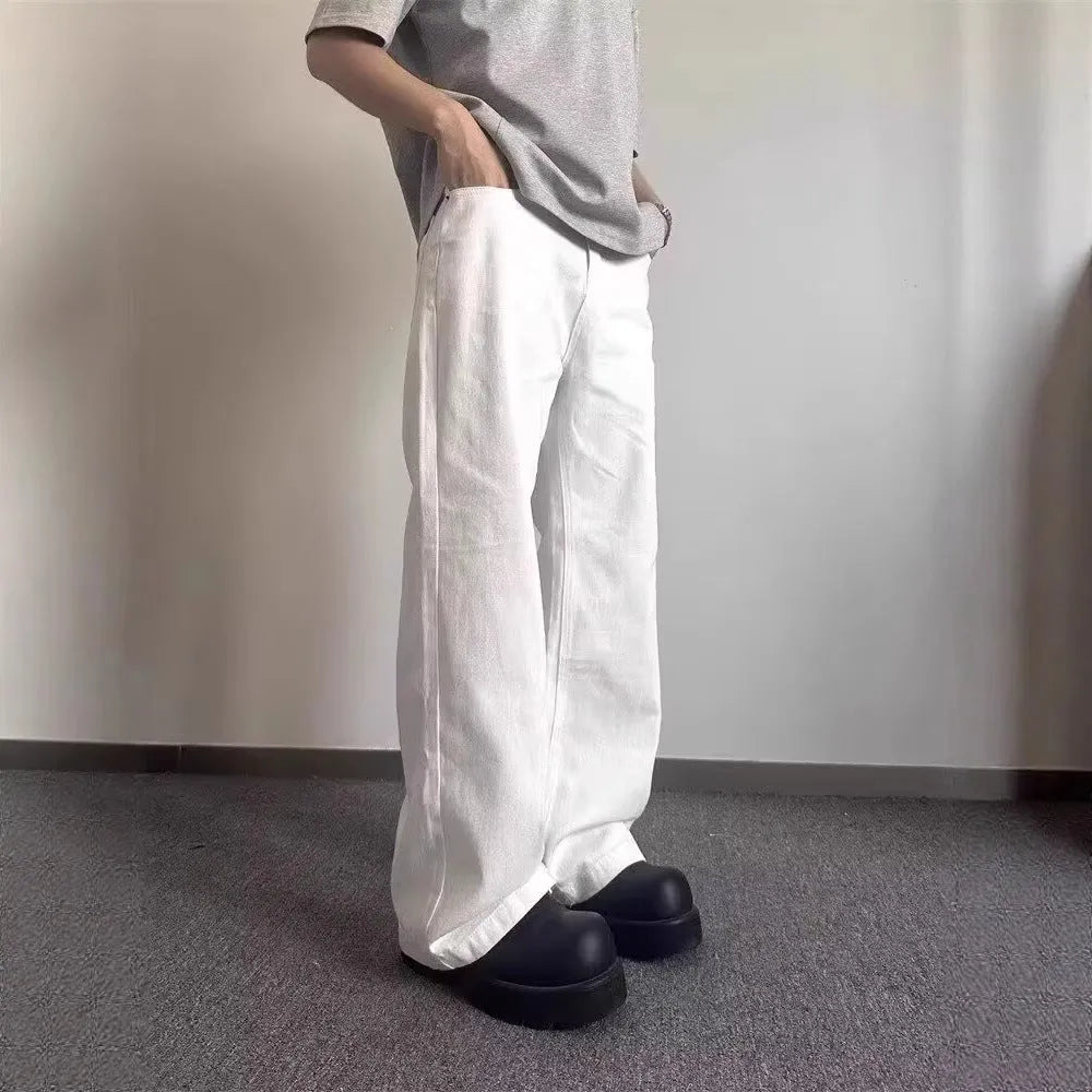 Men's white straight-leg wide-leg cotton denim jeans on a plain background.