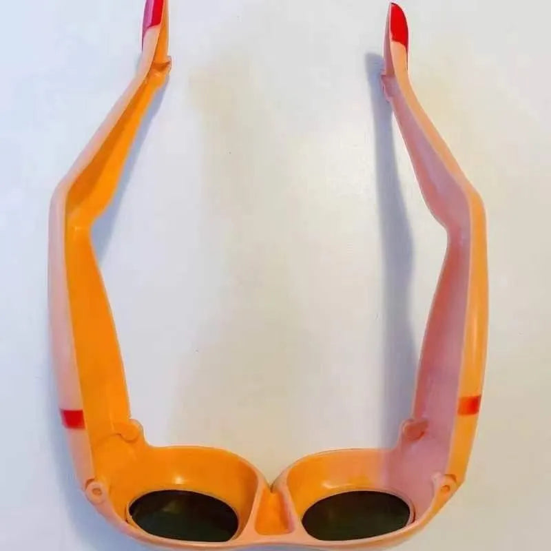 Orange plastic novelty sunglasses with a distinctive leg hip design on the frame.