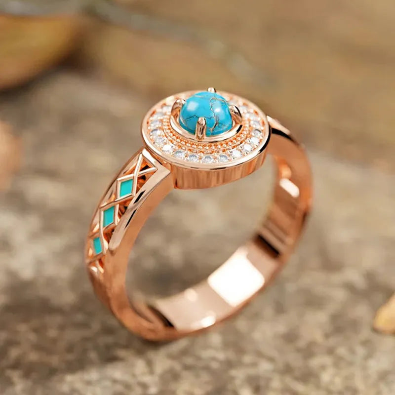 Women's rose gold copper ring with geometric design and inlaid turquoise-style zircon stones.
