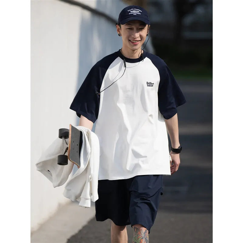 Blue loose-fit men's raglan sleeve T-shirt on a hanger, front view.