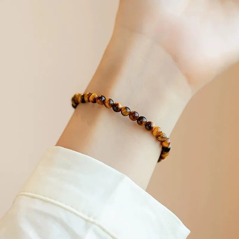 Tigereye stone bracelet with geometric Chinese design showing round elements and bead detailing