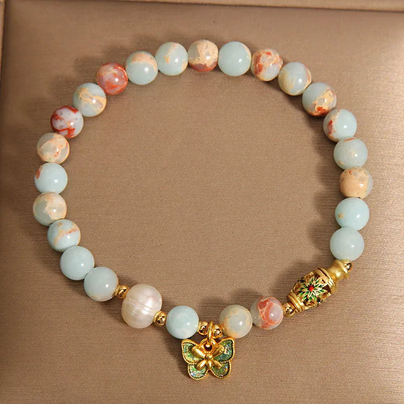 Shoushan stone and freshwater pearl bracelet with blue butterfly pendant on display