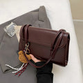 Brown women's Maillard-style PU leather shoulder bag with a double strap and a removable pendant accessory.