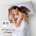 White cotton satin stripe pillow with feather and cotton filler on a bed.