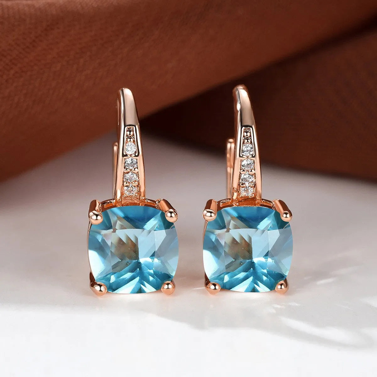 Square geometric ear hook studs with a round zircon stone, shown in a gold electroplated finish.