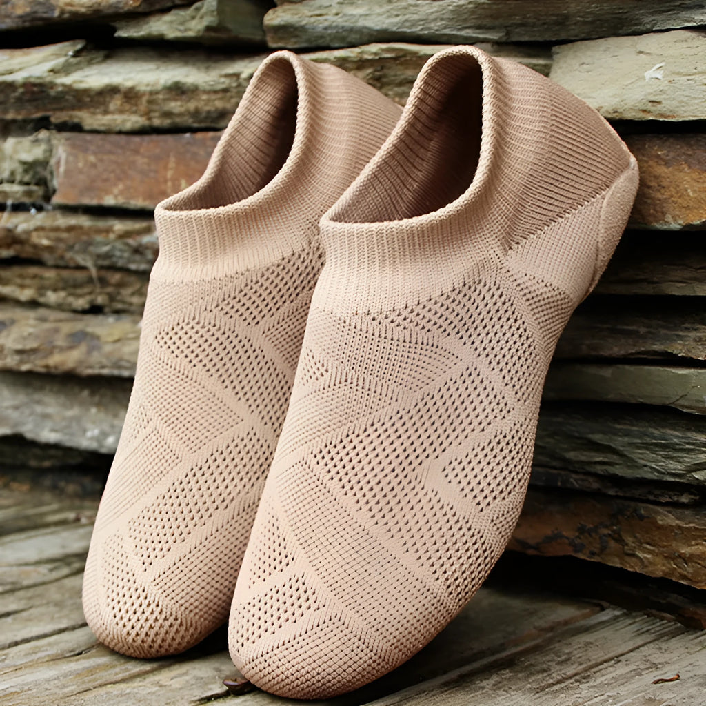 Camel coloured Latin dance shoes with cotton mesh upper and leather sole on a plain background.