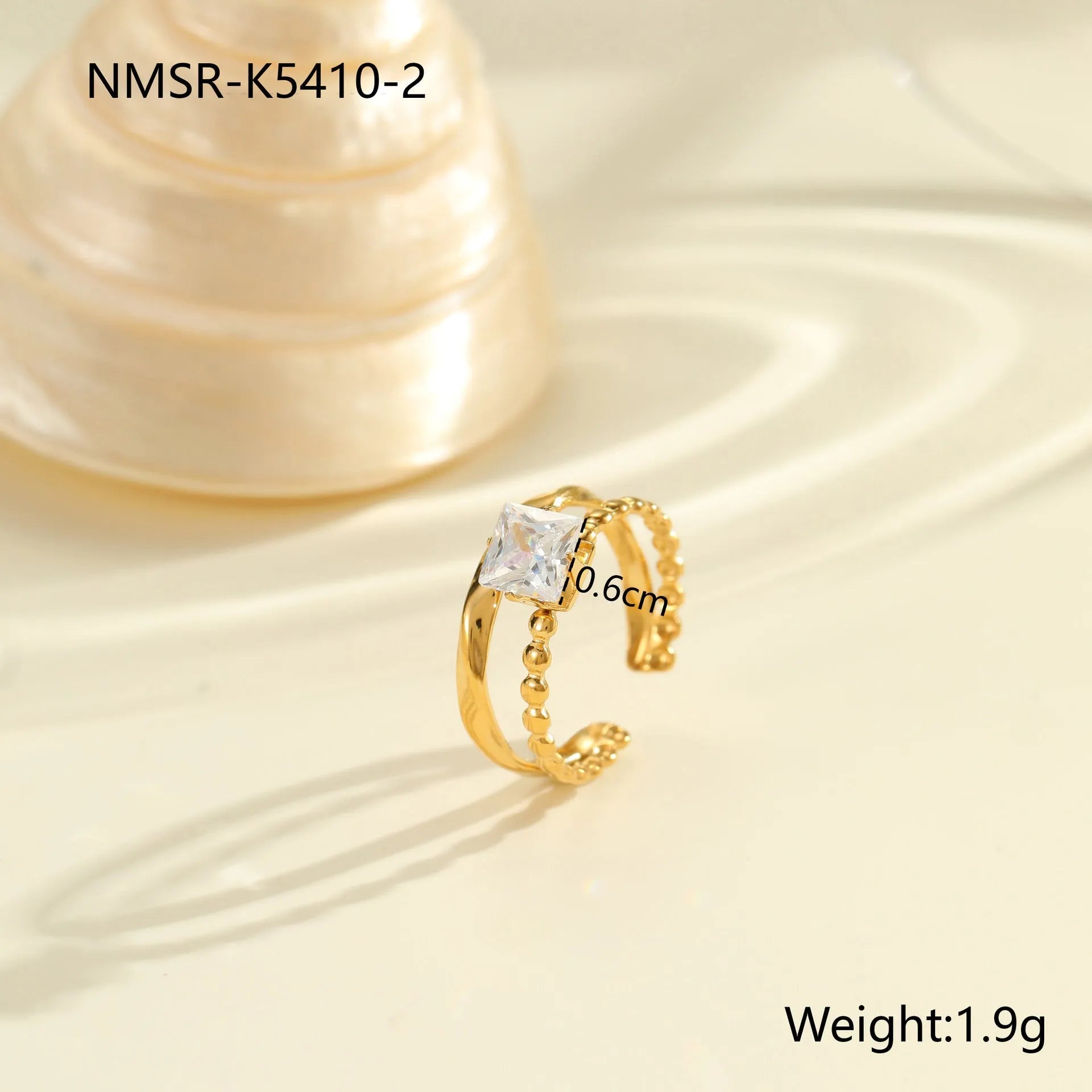 Gold-coloured adjustable stainless steel ring with zircon geometric shapes on white background.