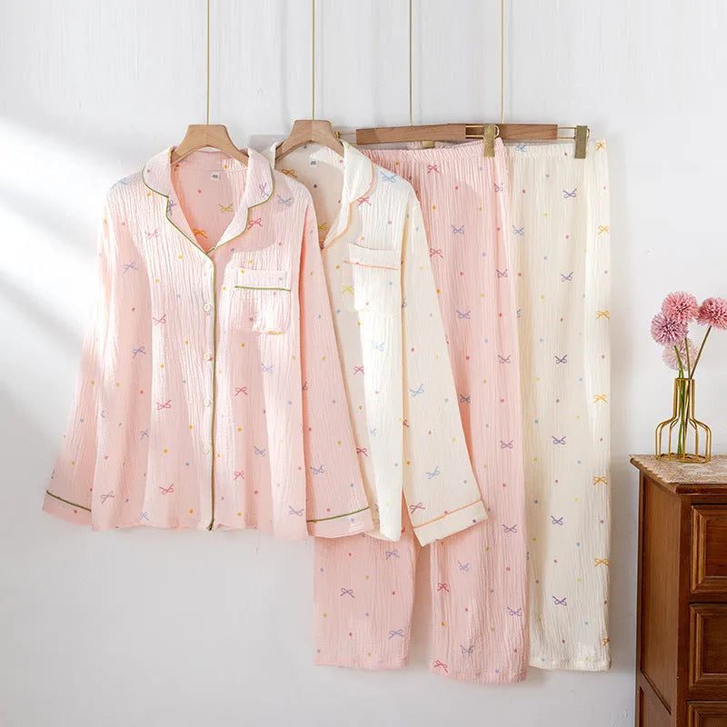 Women's pink cotton long-sleeve pajama top and trousers set laid flat.