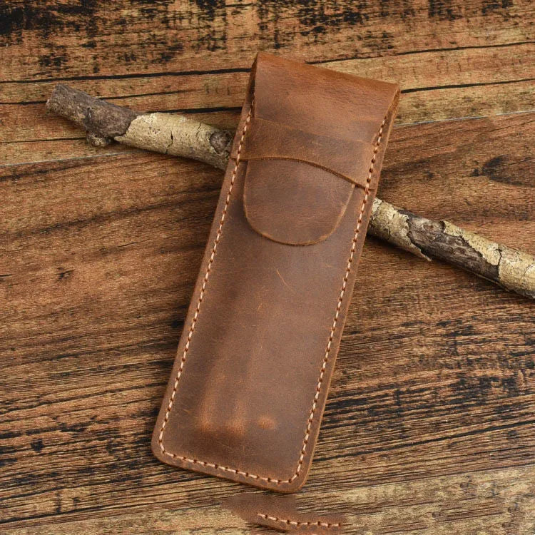 Brown leather pencil case with zip opening on a plain background