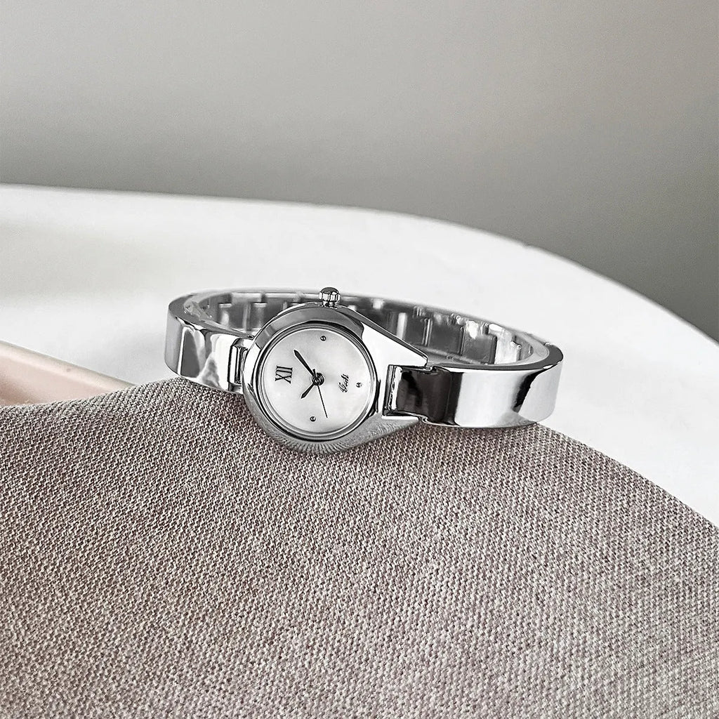Women's quartz watch with 30mm white shell dial, silver hands, and white strap on display