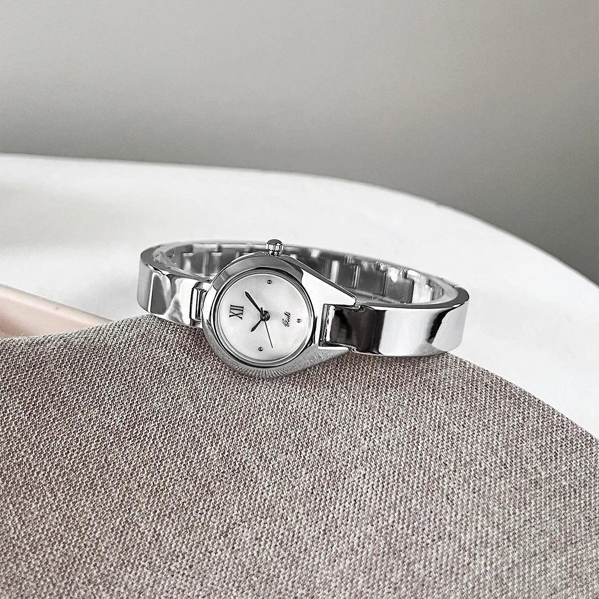 Women's quartz watch with 30mm white shell dial, silver hands, and white strap on display