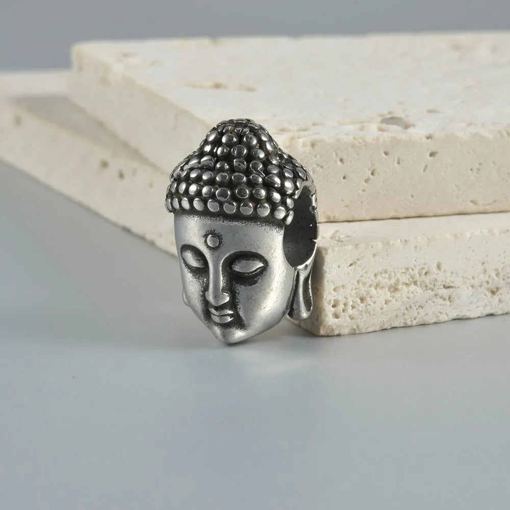 Stainless steel hollow skull Buddha earrings showing four colour finishes on geometry design