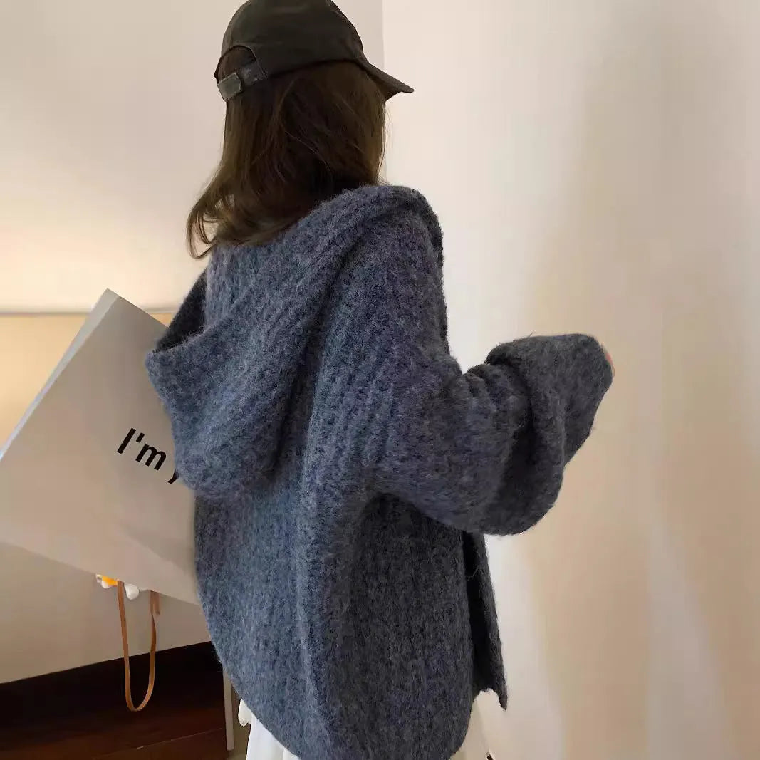 Woman wearing a loose-fit, chunky knit hooded cardigan in a macaron colour.