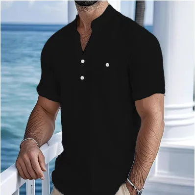 Man wearing a light-coloured, loose fit linen t-shirt with a stand collar and short sleeves.