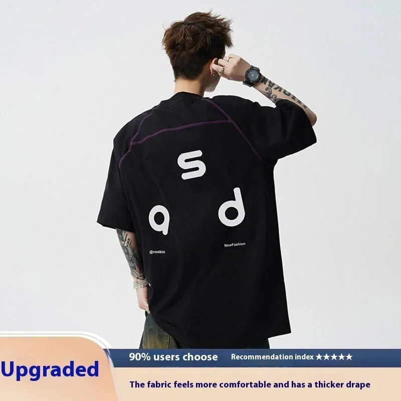 A loose-fitting black cotton t-shirt with letter print detail on the front, showing short sleeves and a round neck.