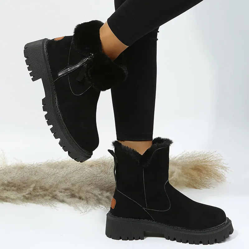 Women's black snow boots with foldable plush tube, suede upper, and rubber sole on winter pavement