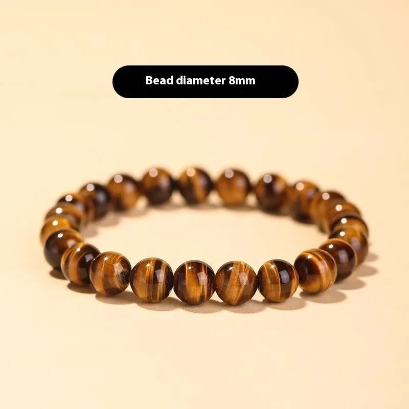 Single Tigereye Dzi bead Buddha rosary bracelet on wrist, showing simple ethnic design.