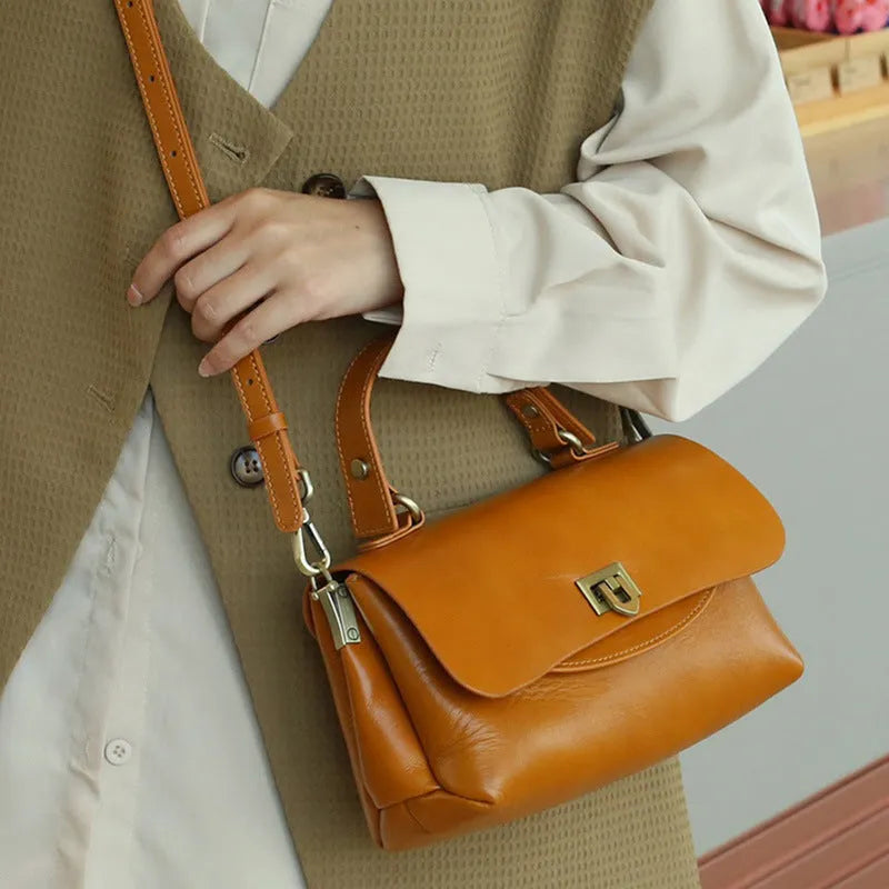 Women's dark brown genuine leather saddle back handbag with multiple compartments and shoulder straps