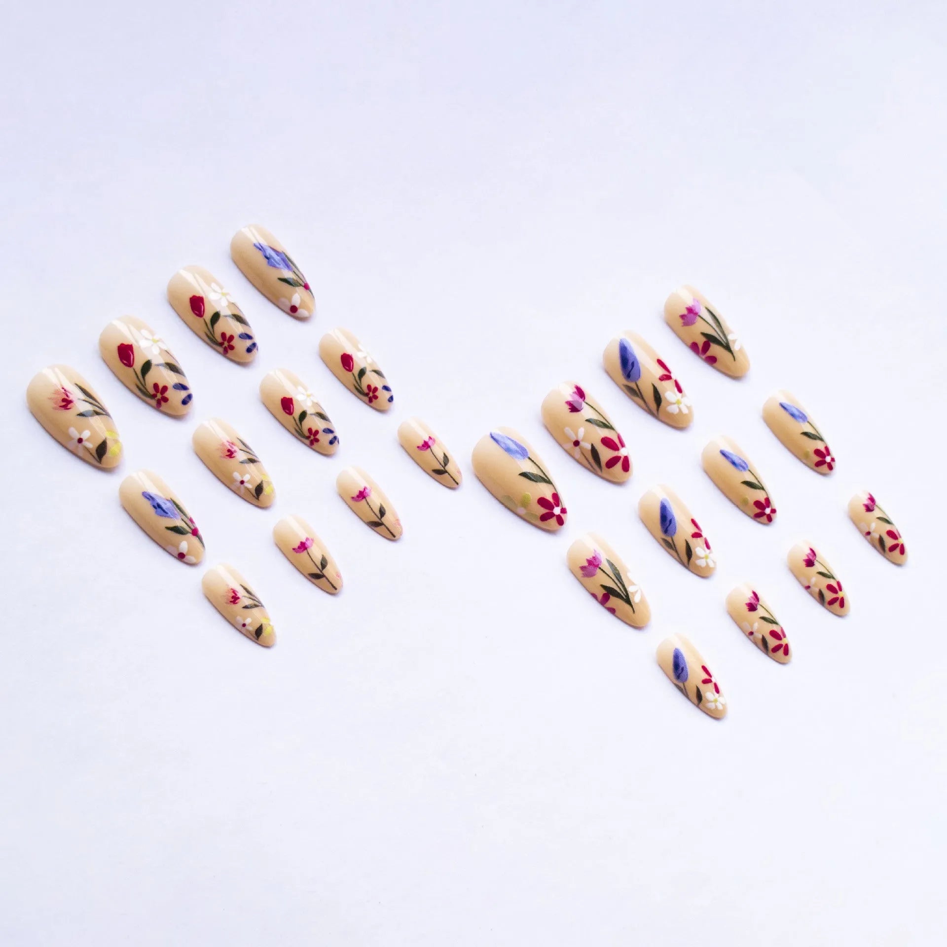 Almond-shaped false nails with detailed 3D pink rose and tulip floral designs on a solid colour base.