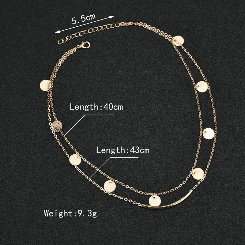 Gold alloy geometric pendant necklace with multi-sequin finish on display
