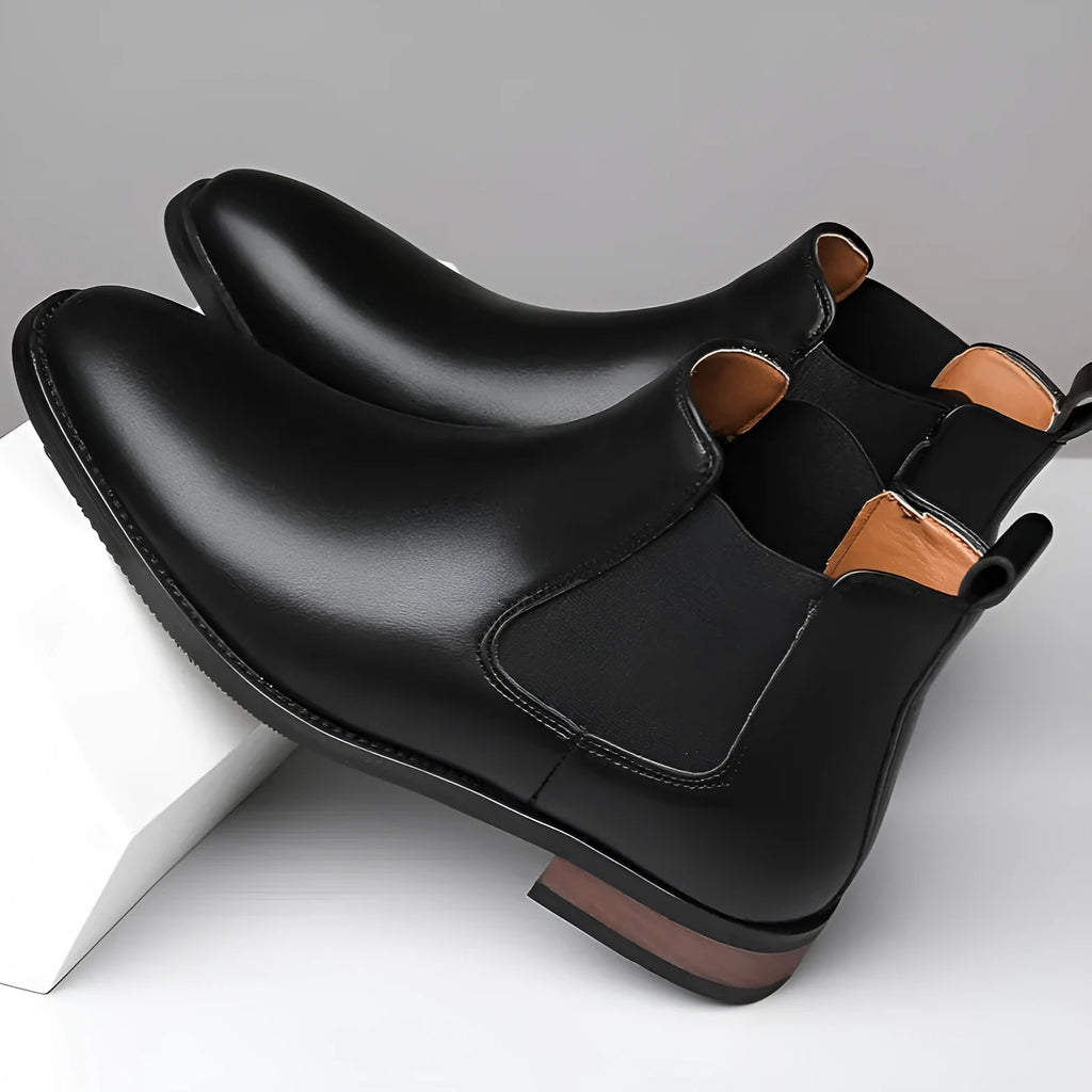 Men's black and light brown pointed toe Chelsea boots with a high-top design and rubber sole.