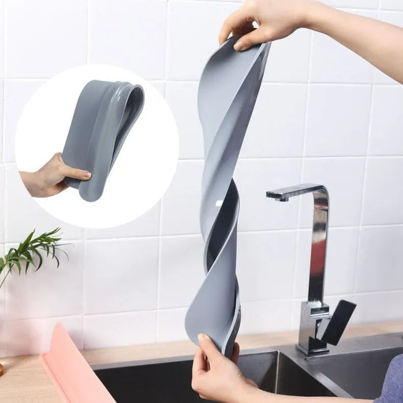 Grey silicone sink splash guard water blocking plate placed on a kitchen sink edge