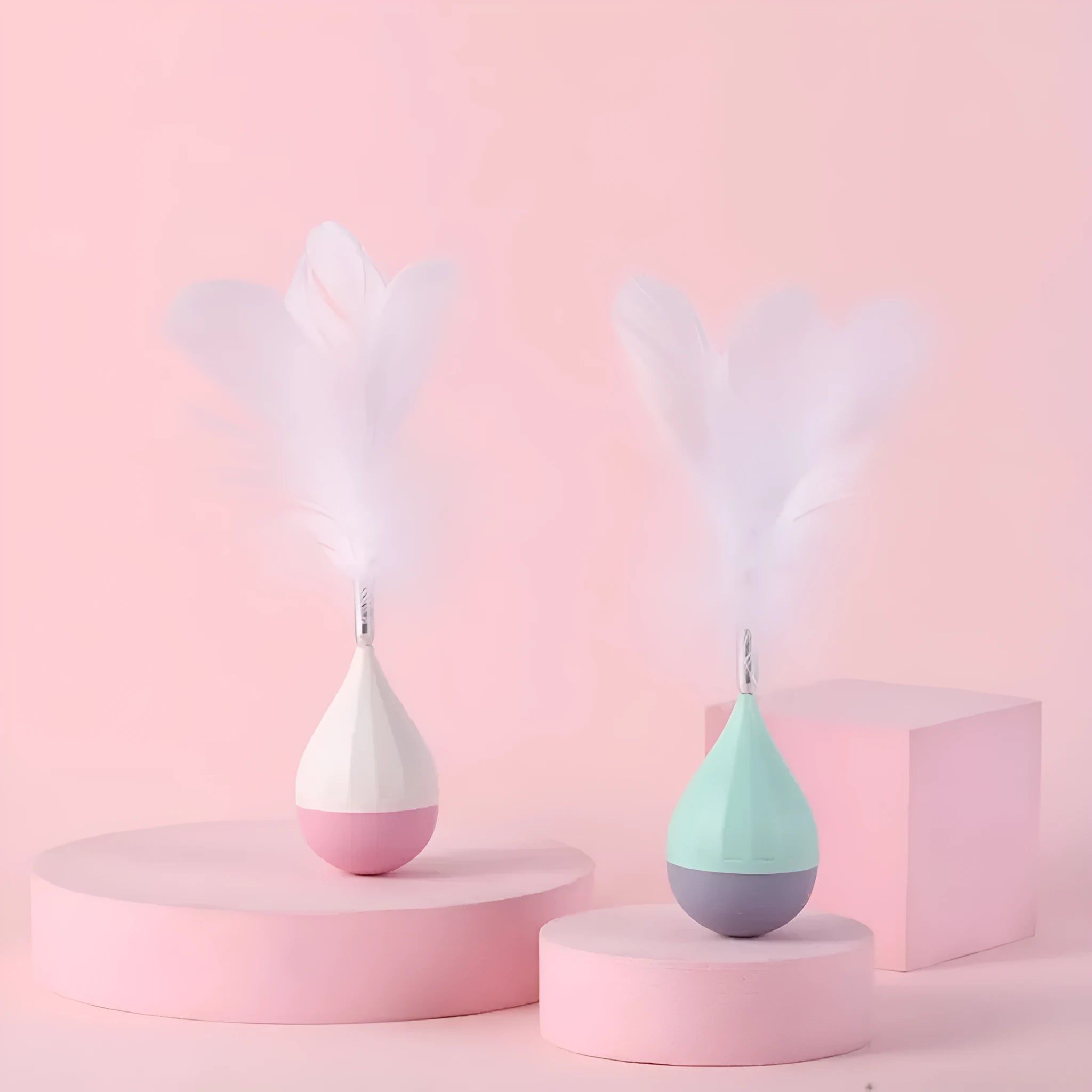 Feather Tumbler Cat Toy with goose feathers and aluminium alloy construction on pink background