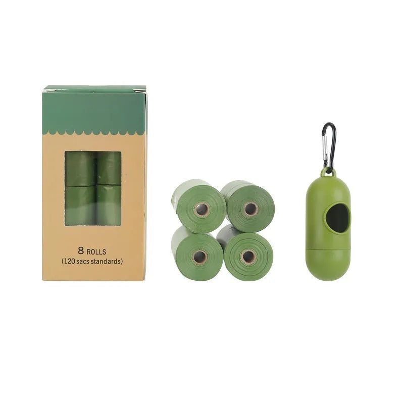 Roll of green EPI degradable dog poo bags next to a white plastic dispenser on a grass background.