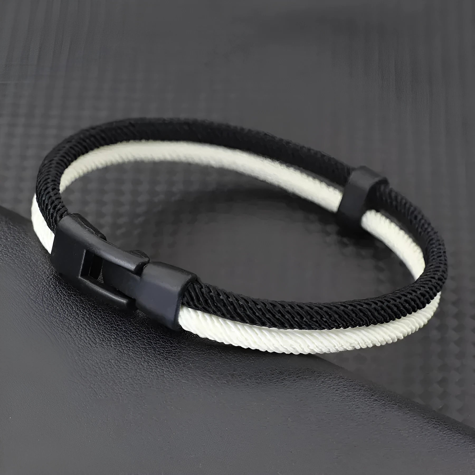 Handmade woven hand strap in black and white colours, showing milan rope alloy construction